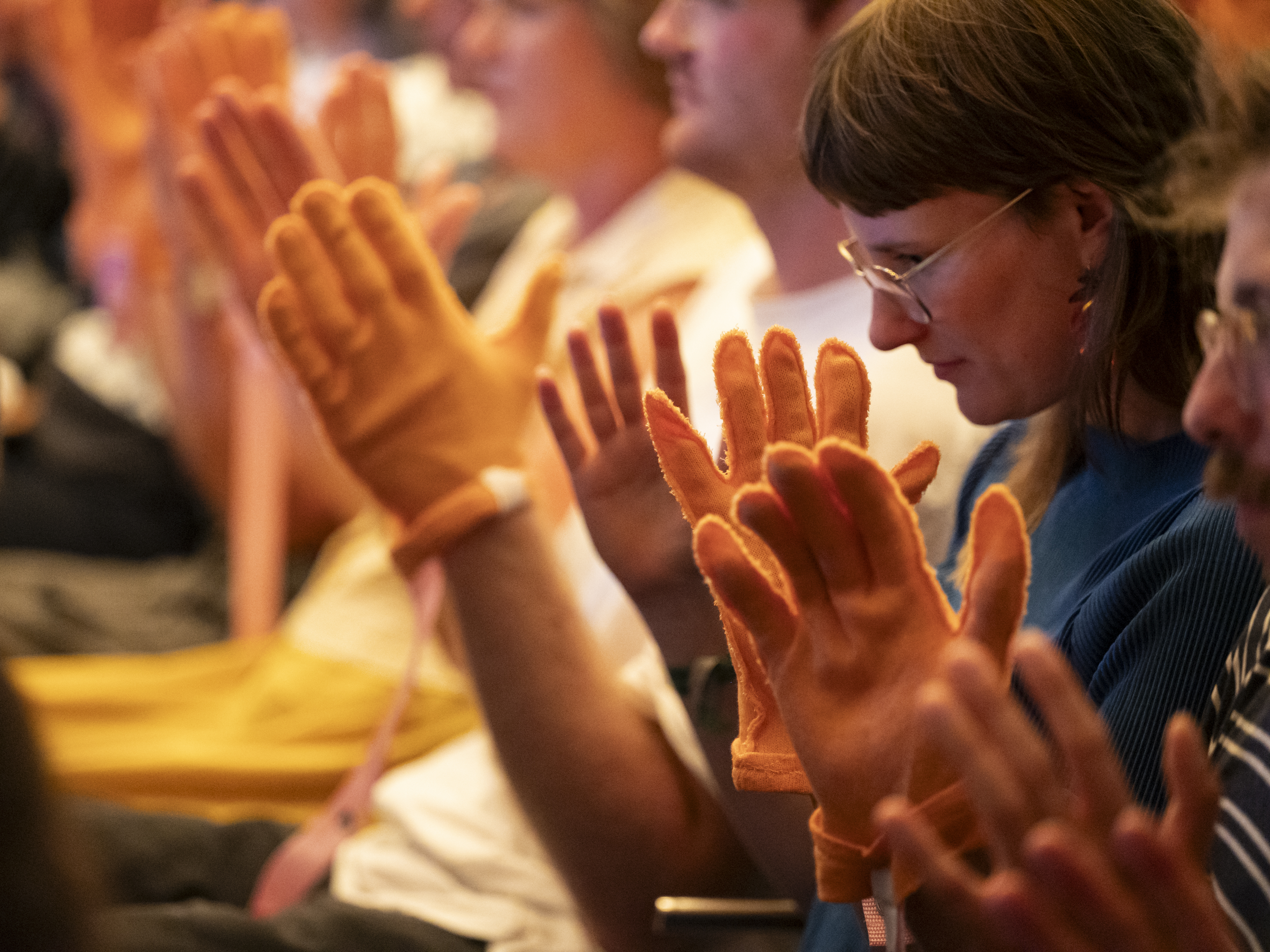 Eine Nahaufnahme von Menschen im Publikum, die die orangefarbenen Anziehbaren tragen.